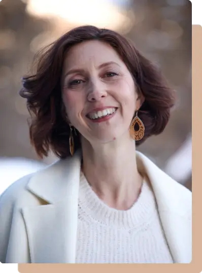 Muriel Joubert souriante avec un long manteau en laine.